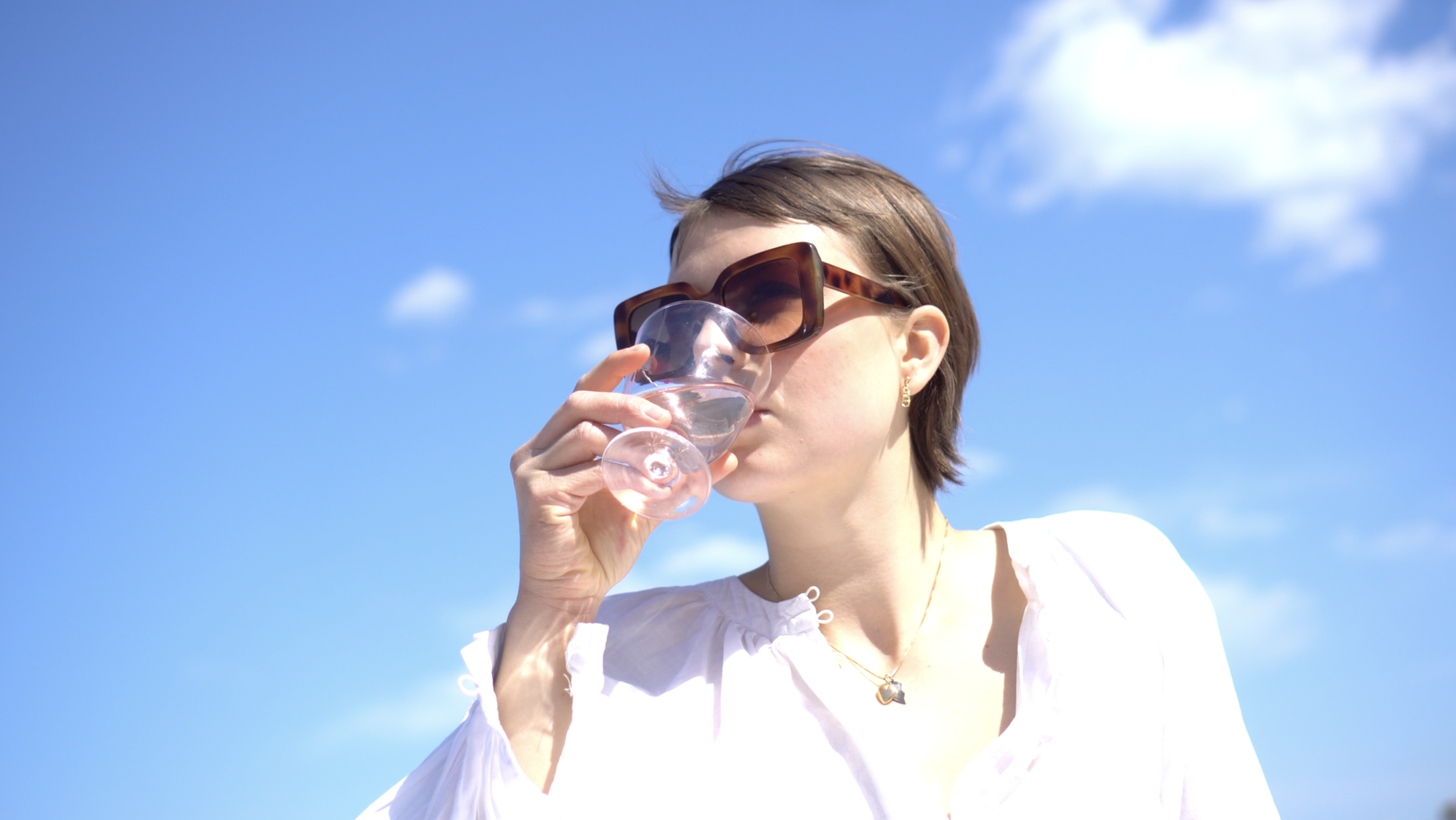 Fria_Frio_Women_drinking_a_glass_of_wine_under_blue_sky